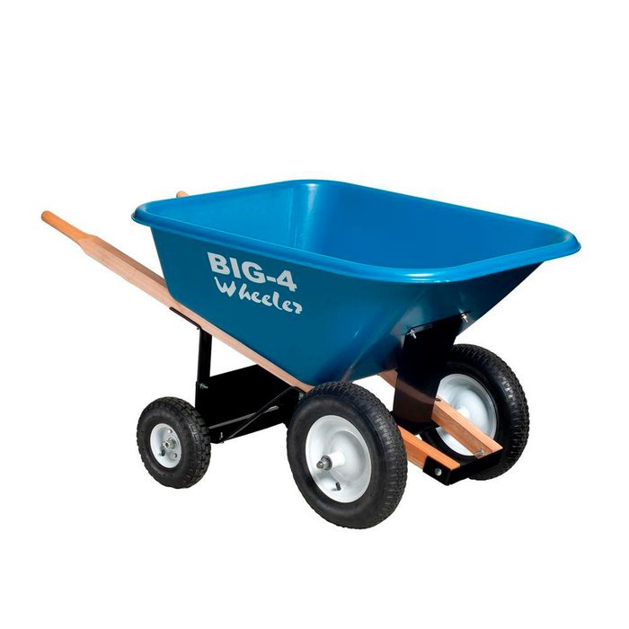 A blue wheelbarrow with a wooden handle and two rubber tires sits upright, indicating readiness for transporting materials in a gardening or construction setting.