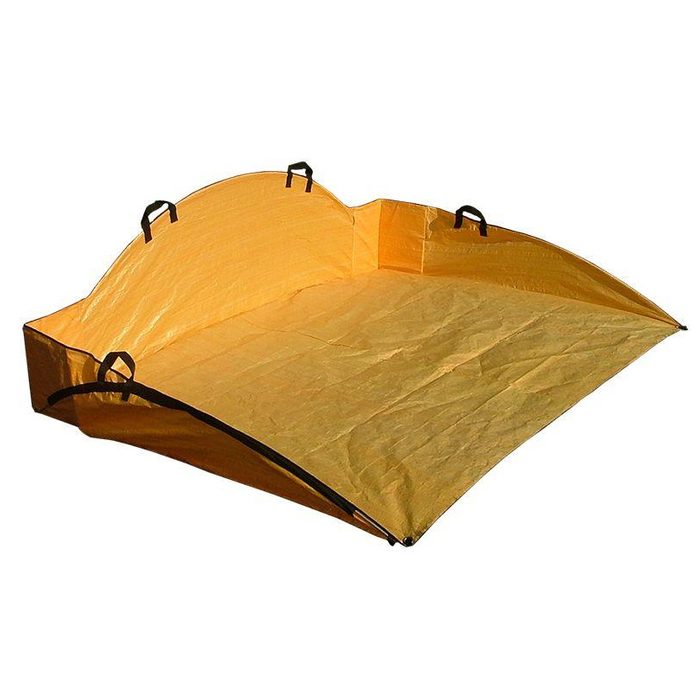A yellow outdoor mat is spread out flat, featuring raised edges and black handles, likely used for sitting or picnicking in a park or camping area.