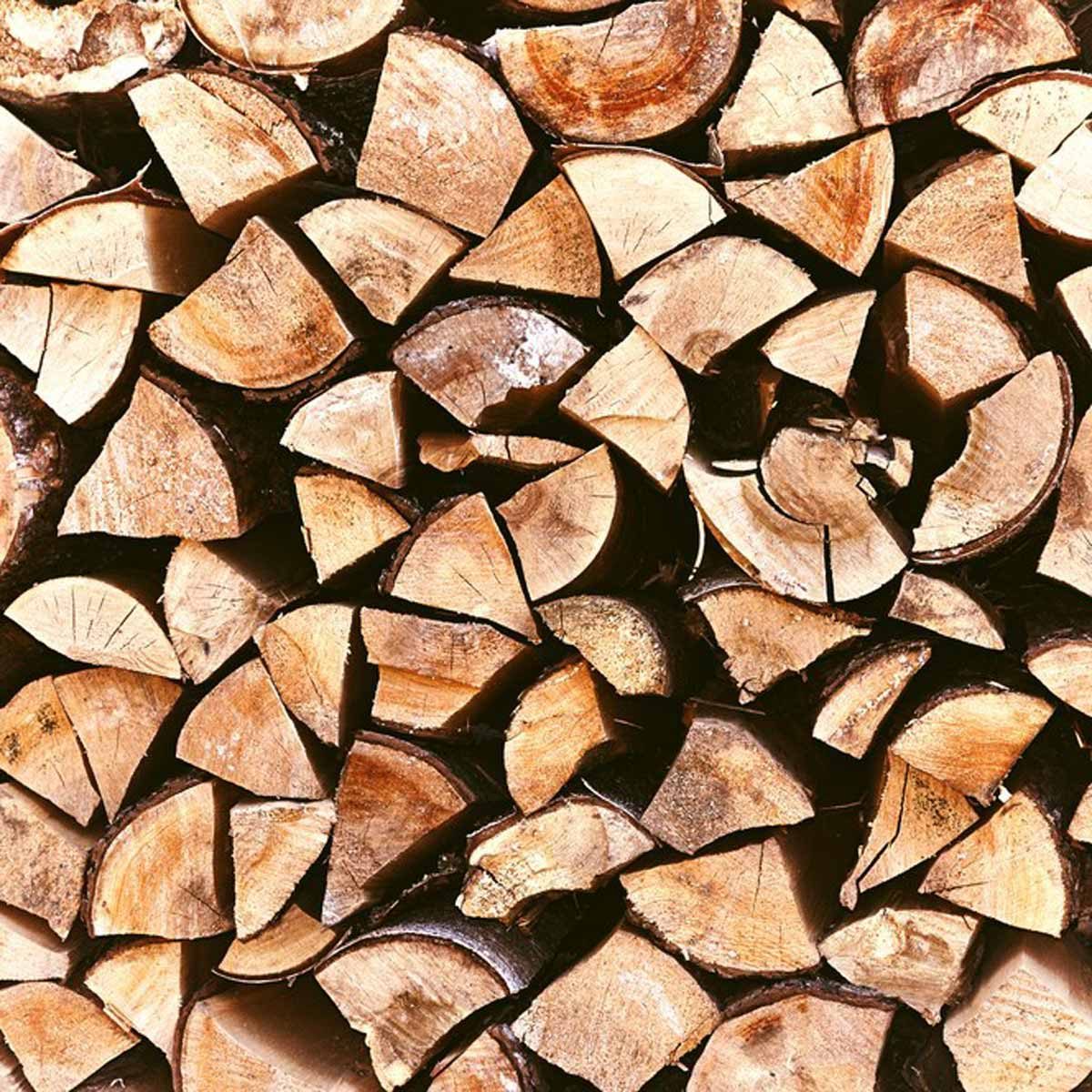 Pile of stacked triangle firewood prepared for fireplace and boiler.