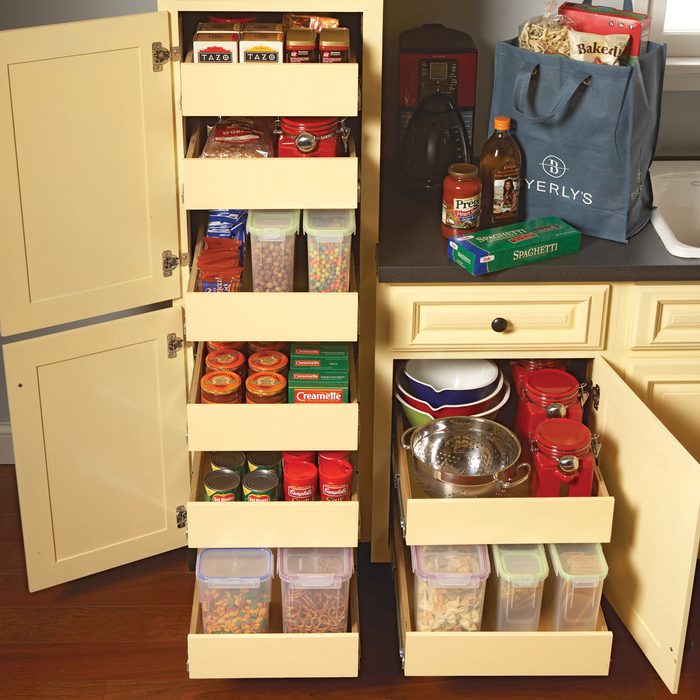 A kitchen pantry displays organized shelves with various food items, while a bag of groceries rests on the countertop beside a kettle and bowls.