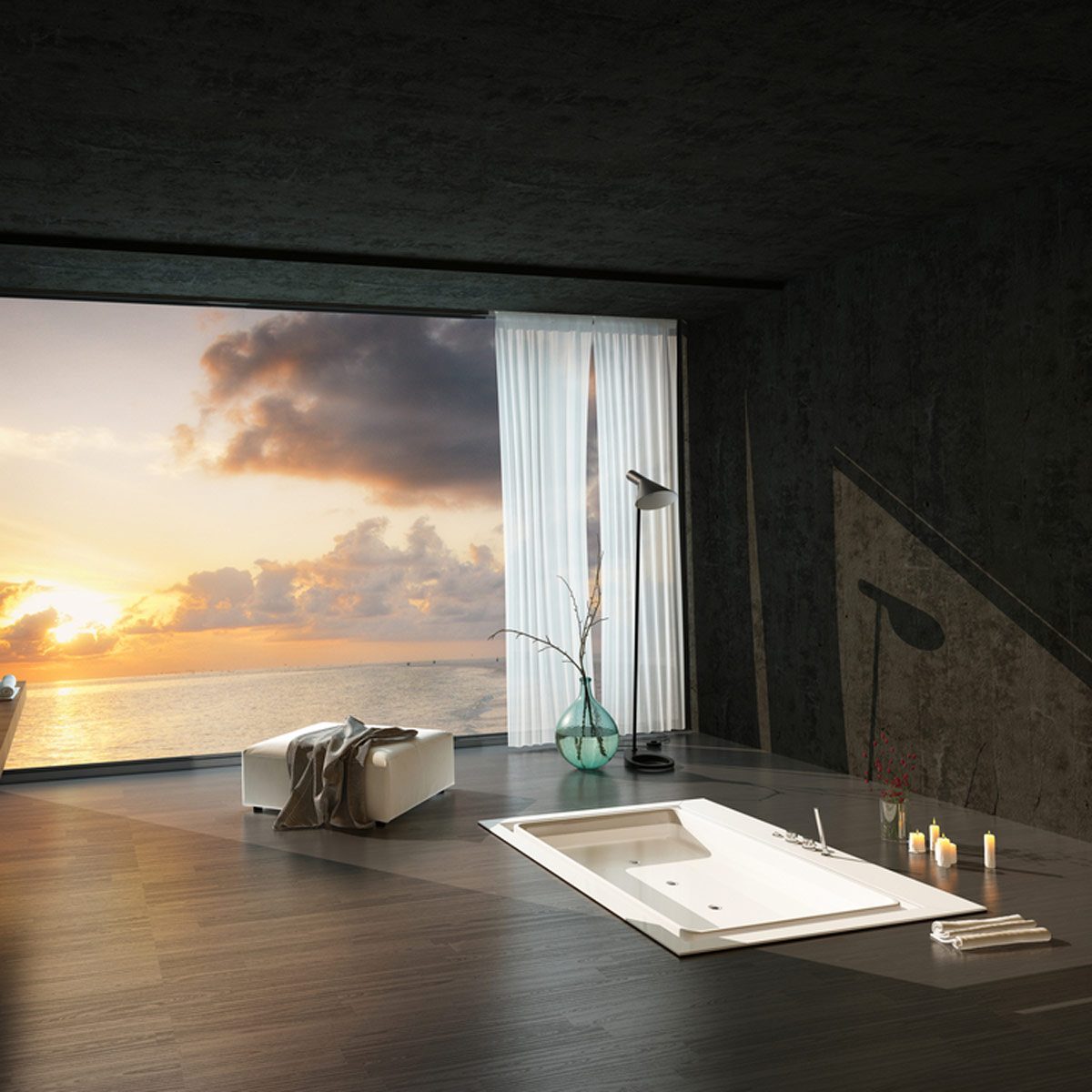 A bathtub sits in a modern room, light softly reflects from floor-to-ceiling windows showcasing a sunset over the ocean. Candles and decor add warmth.