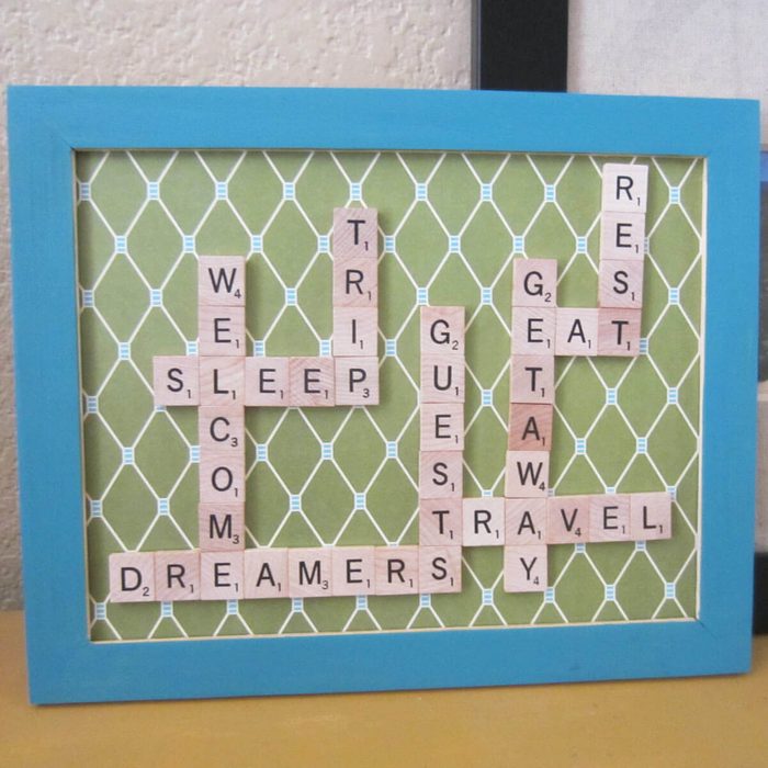 A framed green background displays wooden letter tiles arranged in words like 