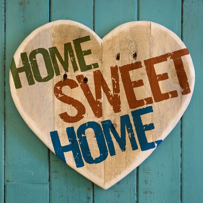 A heart-shaped wooden sign displays the phrase 