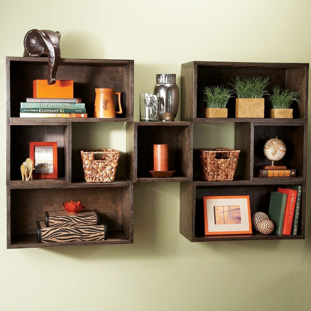 Wooden shelves display various decorative items, books, and plants against a light green wall, creating an organized and visually appealing arrangement.