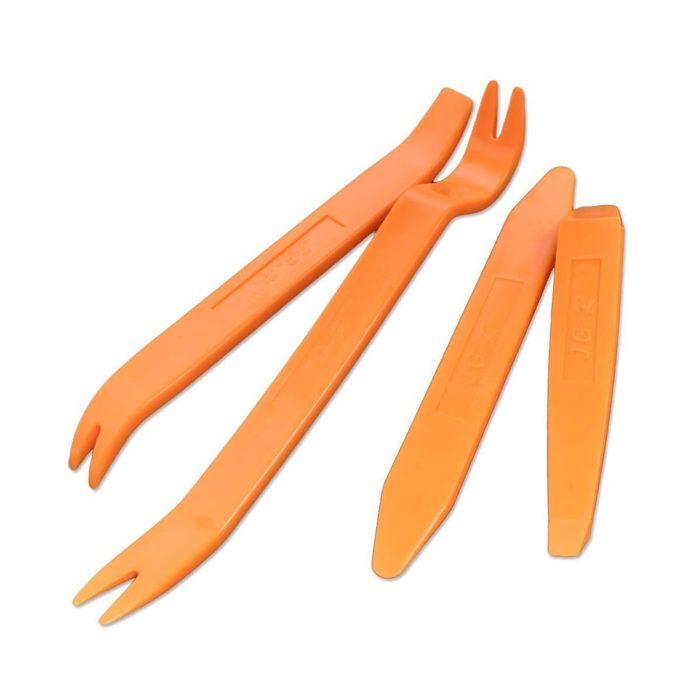 Three orange plastic tools are arranged in a cluster, designed for prying or removing components, likely intended for automotive or electronic use.