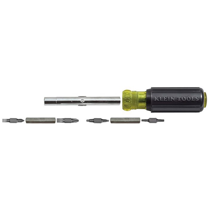 A screwdriver with interchangeable bits lies horizontally, showcasing six metal bits beside it, all against a bright white background.
