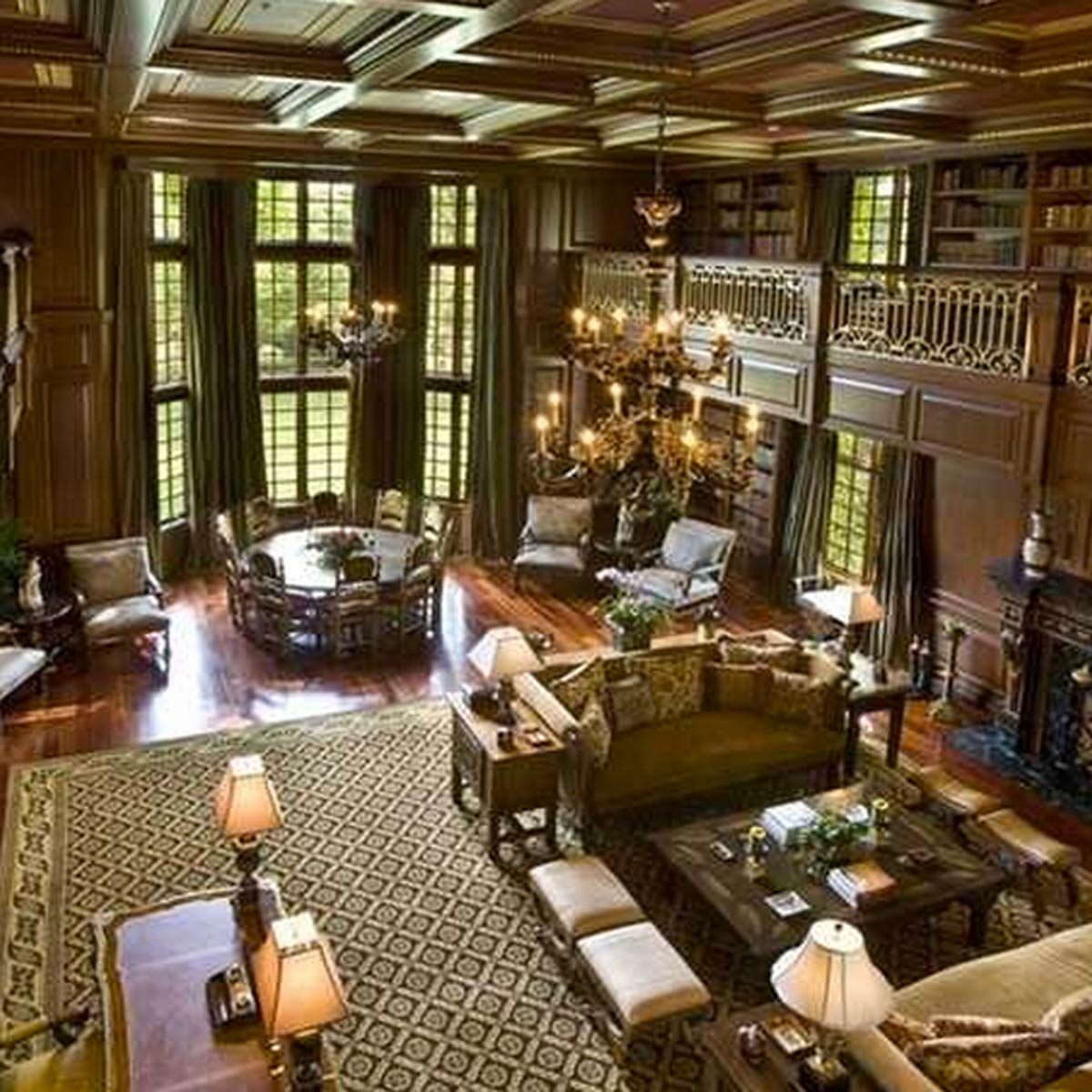 A spacious, elegantly furnished living room features a chandelier, wooden furniture, and large windows, creating a warm, inviting atmosphere with rich textures and colors.