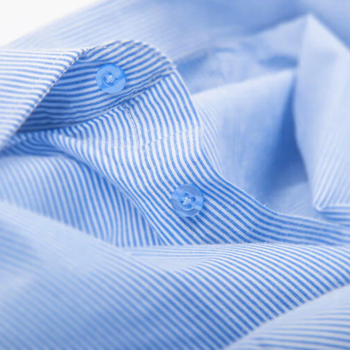 A blue and white striped shirt is partially unfolded, displaying buttons near the collar, set against a light background.
