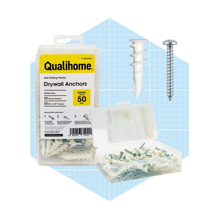 A clear plastic container holds white self-drilling drywall anchors and screws, displaying product information and installation guidelines against a light blue grid background.