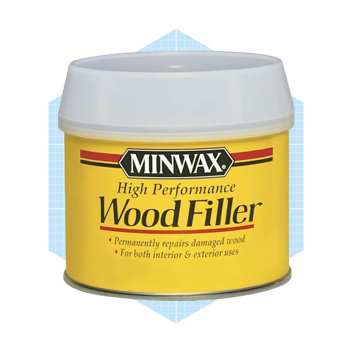 Container of wood filler repairs damaged wood; designed for interior and exterior use, it features a yellow label with product information against a light blue background.