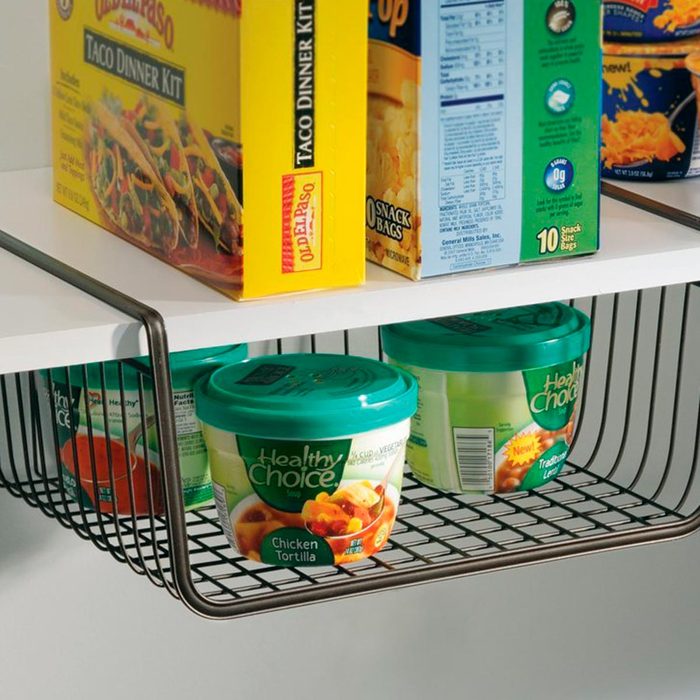 A wire shelf holds various food items, including a taco dinner kit and multiple containers of Healthy Choice soup, organized for easy access.