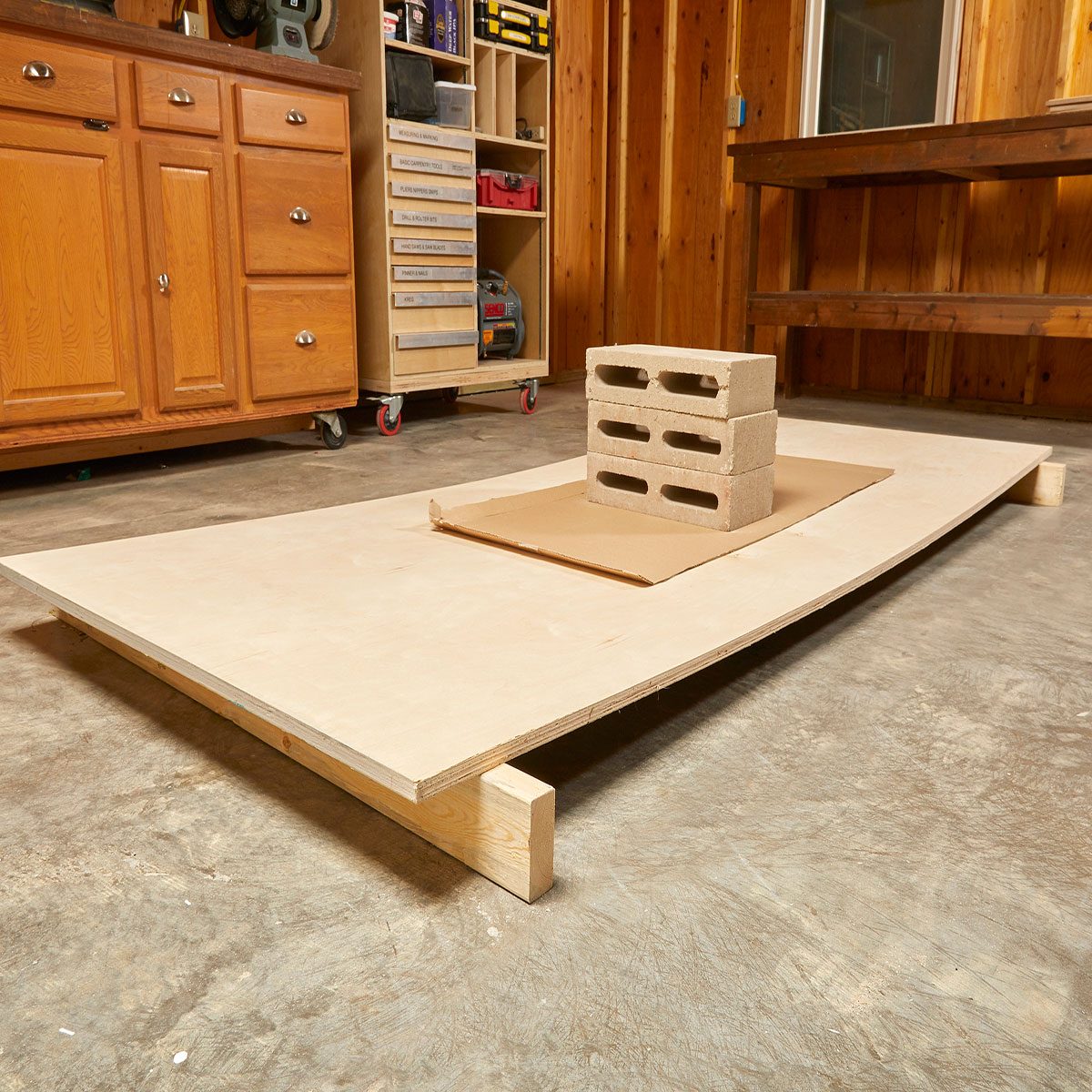 Removing the bow from plywood with cinderblocks | Construction Pro Tips