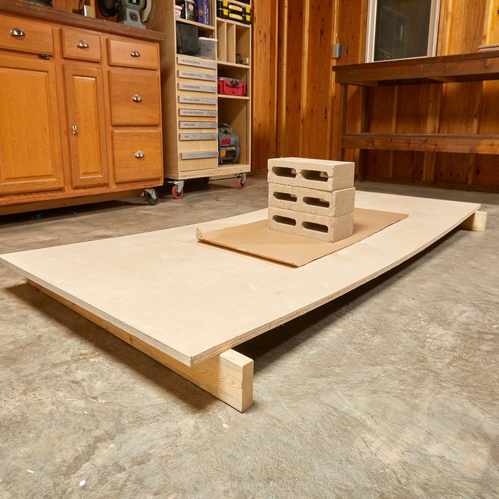Removing the bow from plywood with cinderblocks | Construction Pro Tips