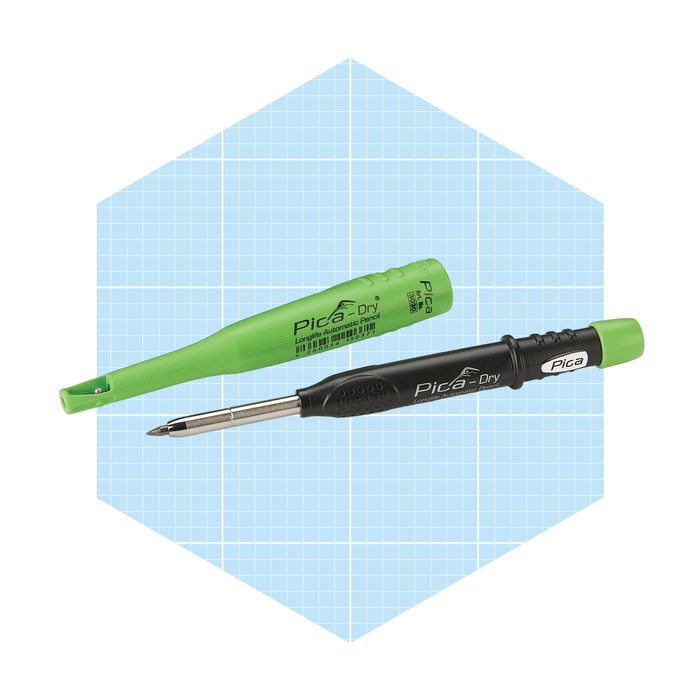 A black and green automatic pencil rests beside its matching cap on a light blue grid background.