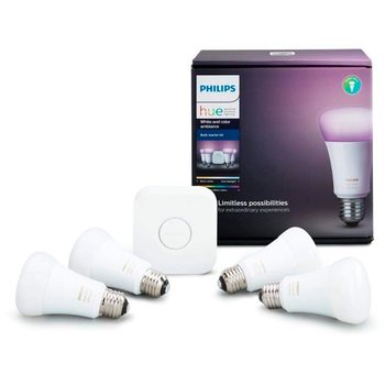 Four smart light bulbs and a control hub sit in front of a packaged product displaying promotional text for Philips Hue lighting.