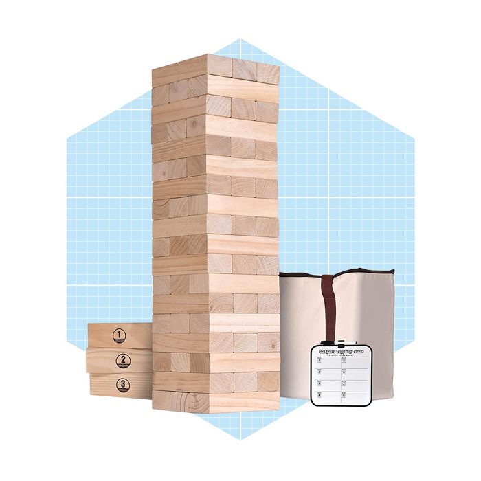 A tall stack of wooden blocks stands upright, with additional blocks and a storage bag nearby, set against a light blue grid background.