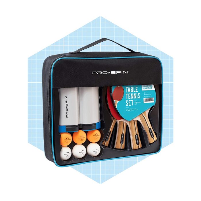 A black carrying case contains table tennis paddles, balls, and storage tubes. It is designed for portable play, set against a light blue grid background.