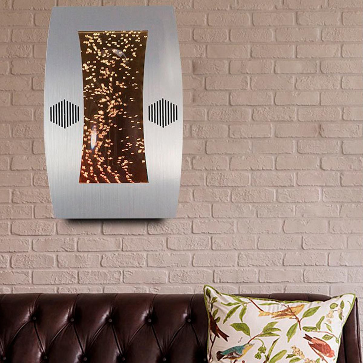 A modern wall-mounted water feature creates a calming flow, surrounded by a textured brick wall and a brown leather sofa with decorative pillows.