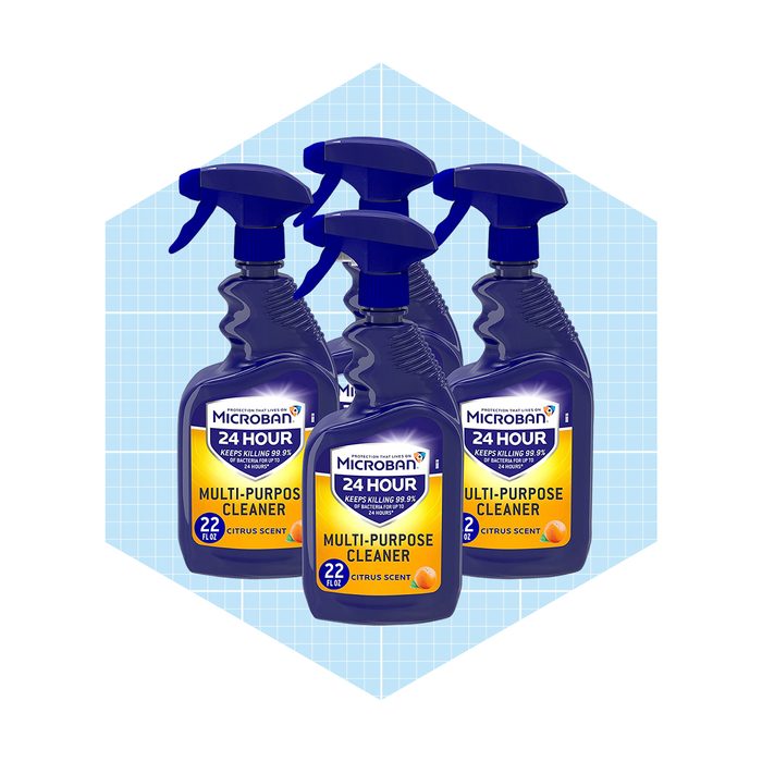 Four spray bottles of Microban multi-purpose cleaner are arranged together. They are designed for cleaning, featuring a citrus scent. The background is a light blue grid.