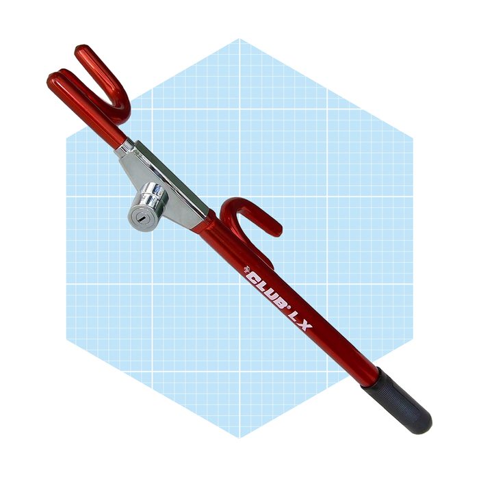 A red locking device with hooks on both ends secures a steering wheel, providing anti-theft protection in a light blue grid background.