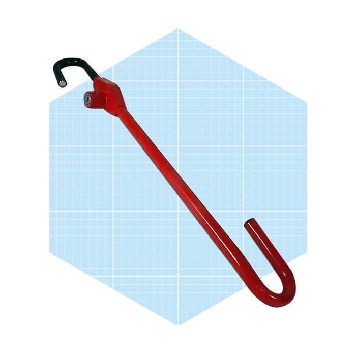 A red pry bar rests diagonally, designed for leverage, against a light blue grid backdrop, suggesting a workshop or tool-related context.