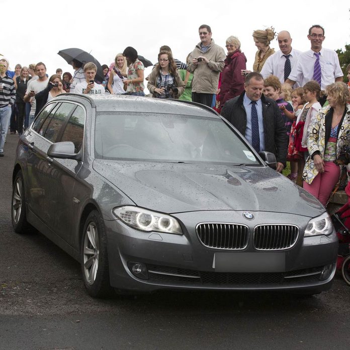 Prince William and Catherine Duchess of Cambridge drive in a gray BMW wagon
