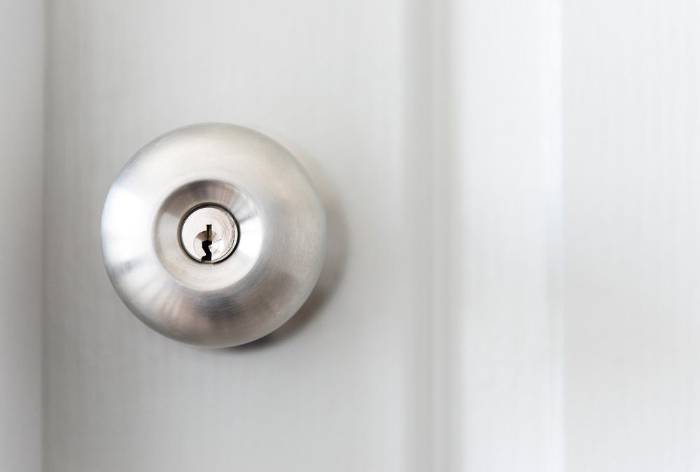 white door with metal doorknob is regular lock style in a house, copy space.