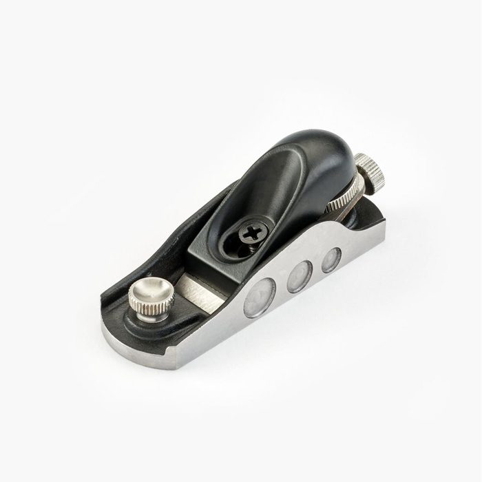 A compact hand plane crafted with a black handle and silver base, designed for smoothing wood surfaces on a plain white background.