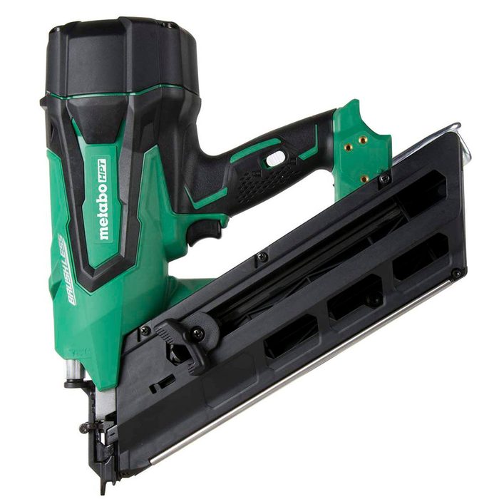 A green and black cordless nail gun is positioned at an angle, showcasing its handle and loading chamber, designed for fastening materials in construction.