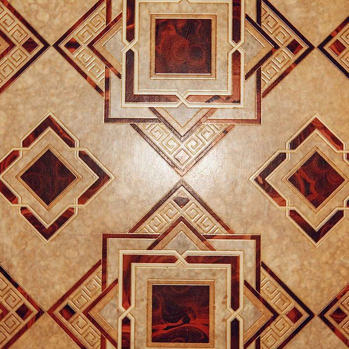 A patterned floor features interlocking geometric shapes in brown and cream, creating a decorative design with a blend of textures and colors.