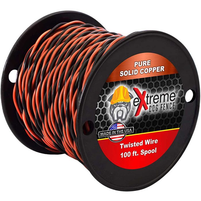 Twisted copper wire is coiled on a black spool, labeled for use in dog fencing. It measures 100 feet and features a black and orange color scheme.