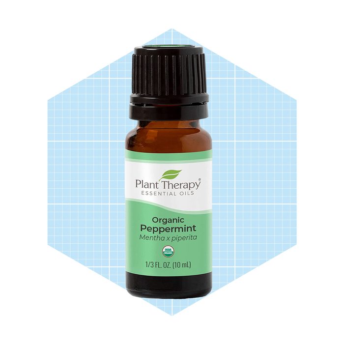 A small amber glass bottle of peppermint essential oil is displayed, labeled 