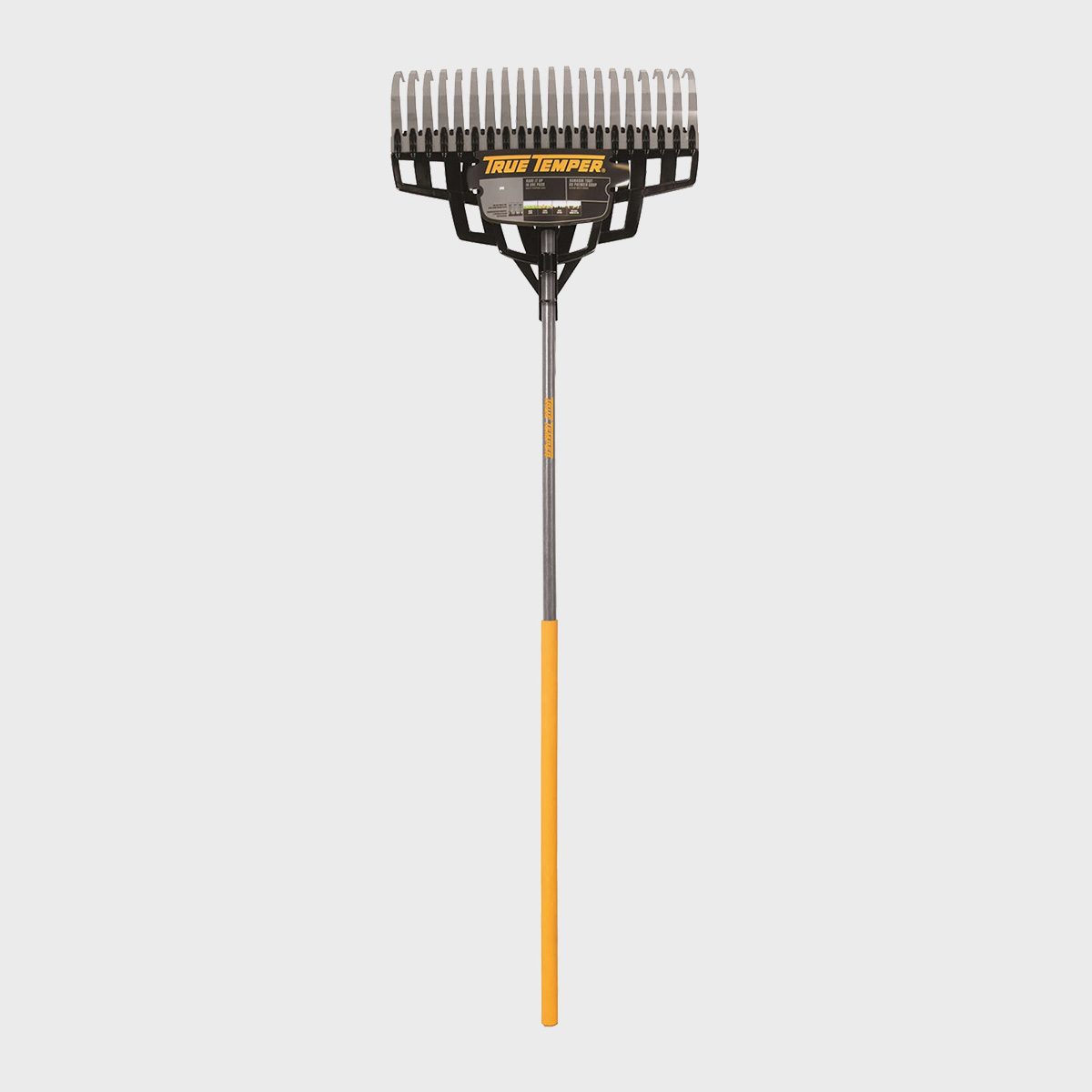 A garden rake stands upright, with a wide head featuring elongated tines. Its handle is orange and extends downward, set against a plain background.