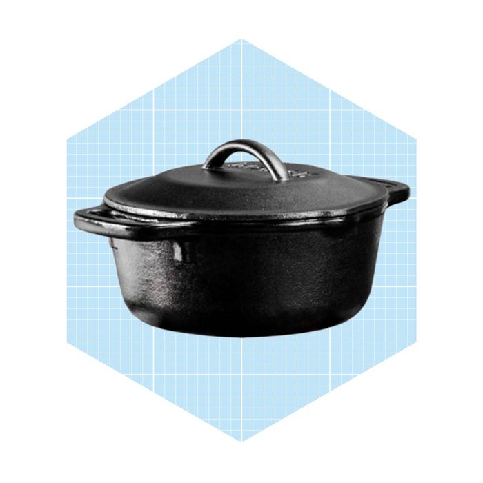 A black cast iron pot sits on a light blue grid-patterned background, showcasing its smooth surface and sturdy handle, ready for cooking.