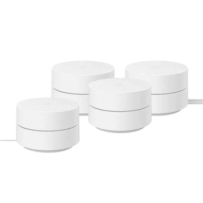 Four cylindrical, white devices are positioned close together on a flat surface, each slightly raised, and connected by a single cable.