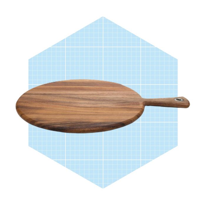 A wooden serving board rests flat with a handle; it is set against a light blue, geometric background.