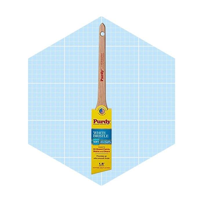 A paintbrush with a soft white bristle rests upright against a light blue grid-patterned background, showcasing brand information and usage instructions.