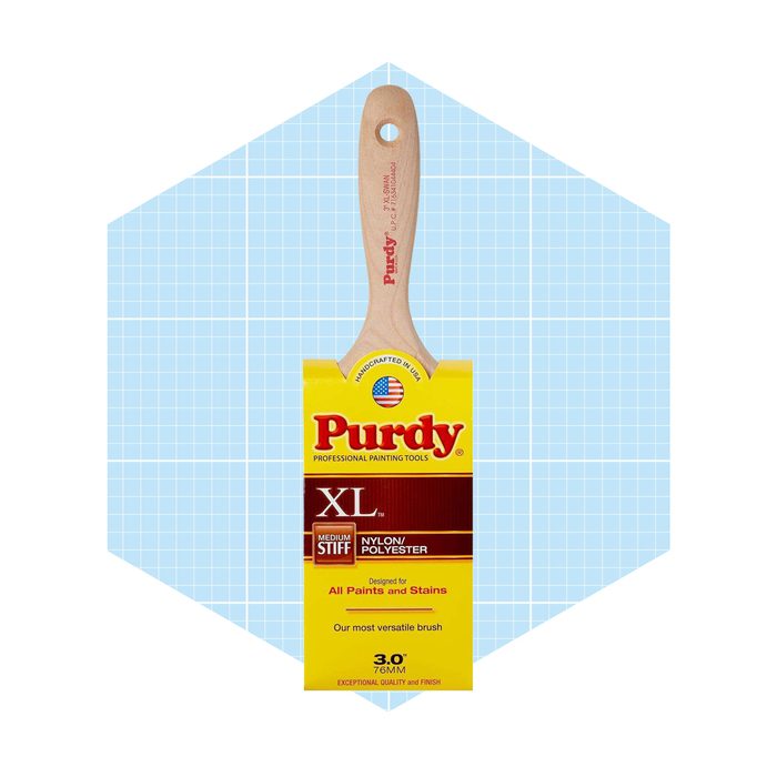 A paintbrush with a wooden handle rests against a light blue grid background, featuring packaging that highlights its versatility for all paints and stains.