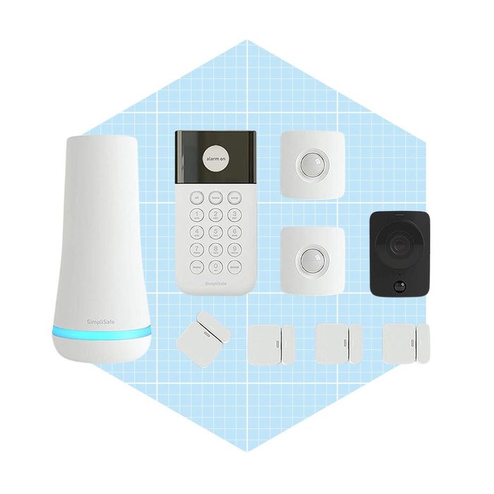 A home security system layout includes a base station, keypad, sensors, and a camera, all arranged on a light blue grid background.