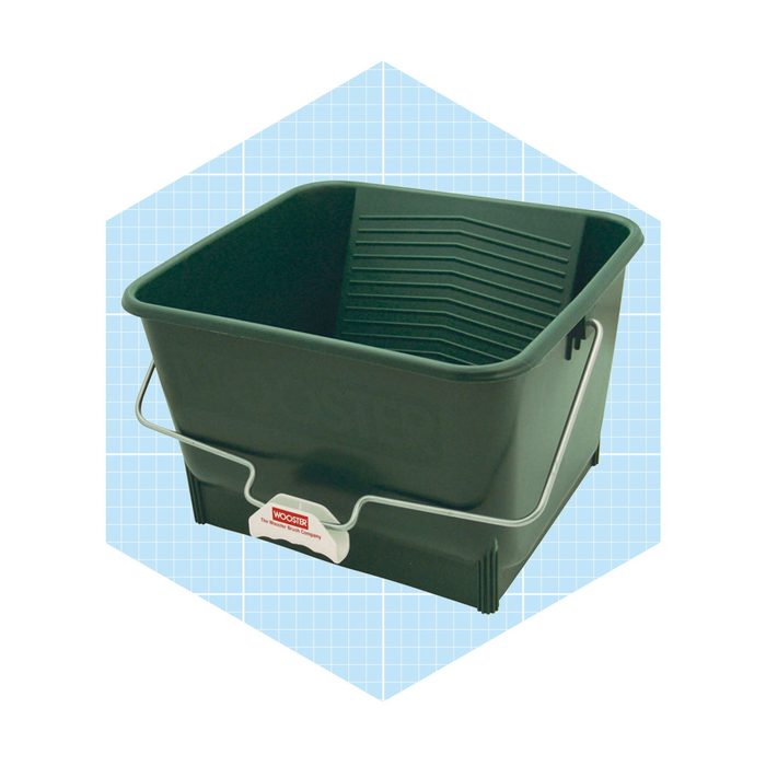 A green plastic bucket sits on a light blue grid background, featuring a metal handle and a textured interior for optimal cleaning use.
