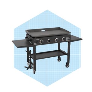 A black outdoor griddle with four control knobs cooks food on a flat surface, positioned on a wheeled cart that includes side shelves.