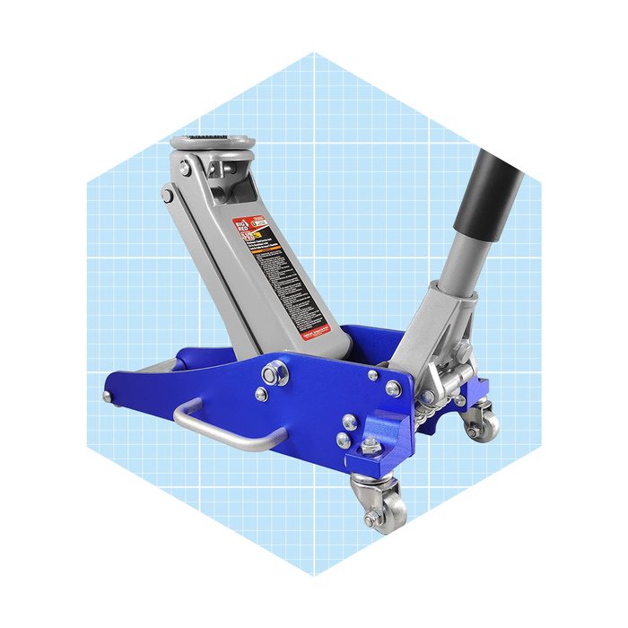A hydraulic car jack is positioned upright, ready for lifting. Its sturdy blue base includes wheels, set against a light blue grid background.