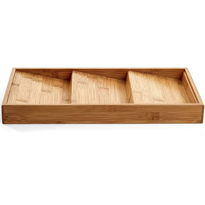 A bamboo tray with three compartments, positioned flat, designed for organizing items, showcasing smooth, tan wood grain against a white backdrop.