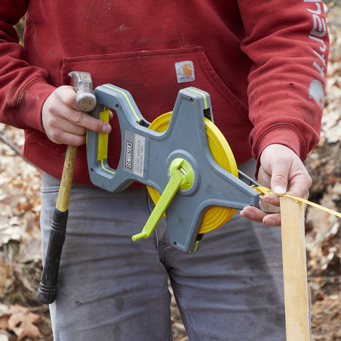 Man puts up a silt fence around Family Handyman