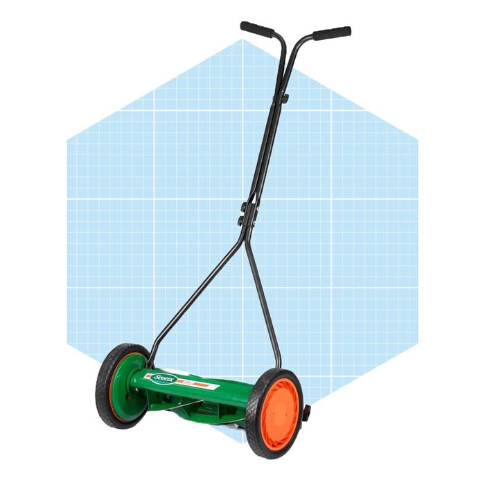 A green manual reel lawn mower with orange wheels stands against a light blue grid background, designed for cutting grass without a motor.