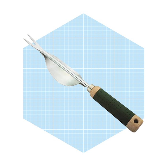 A hand tool with a curved blade and prongs is positioned upright against a blue grid background, designed for gardening tasks like digging or cultivating soil.