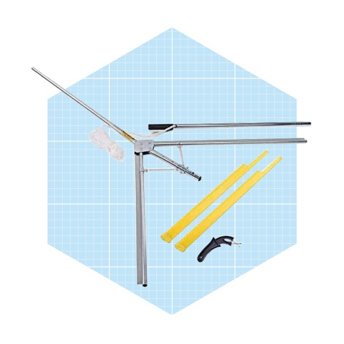 A metallic tool with complementary yellow rods and a black handle is positioned against a blue grid background, likely indicating a setup for measurement or construction.