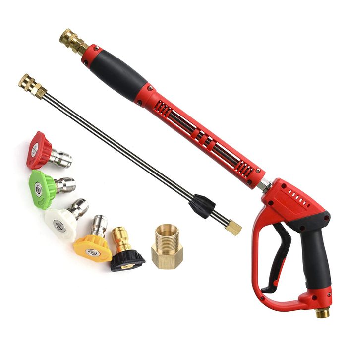 A red and black pressure washer wand is displayed alongside various nozzles and a brass connector, ready for use in cleaning tasks.