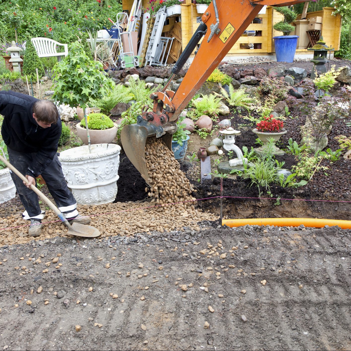 placing rocks and gravel over french drain pipe system