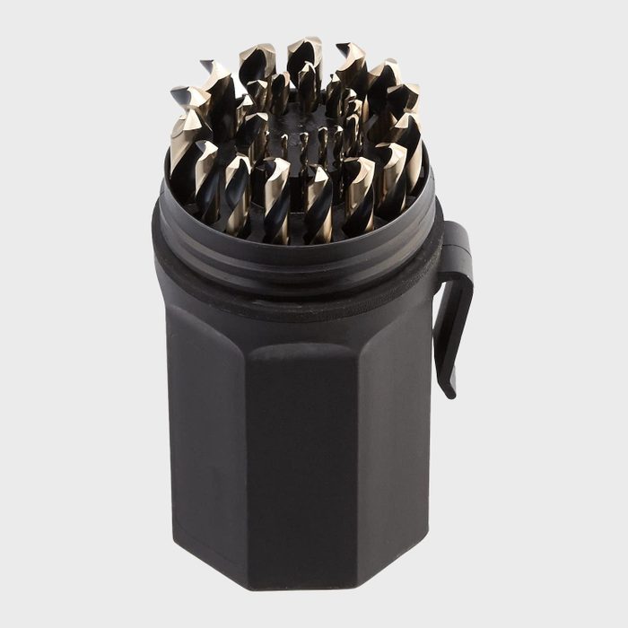 A cylindrical container holds multiple metal drill bits, standing upright. The container has a black exterior and features an opening at the top.